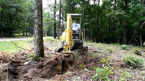 can a mini excavator remove trees|mini excavator push over tree.